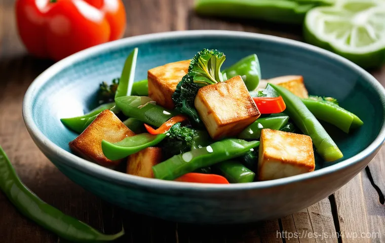 대체육 활용을 위한 비건 요리 팁 - **Prompt:** A close-up, high-angle shot of a vibrant vegan stir-fry, showcasing perfectly golden-bro...